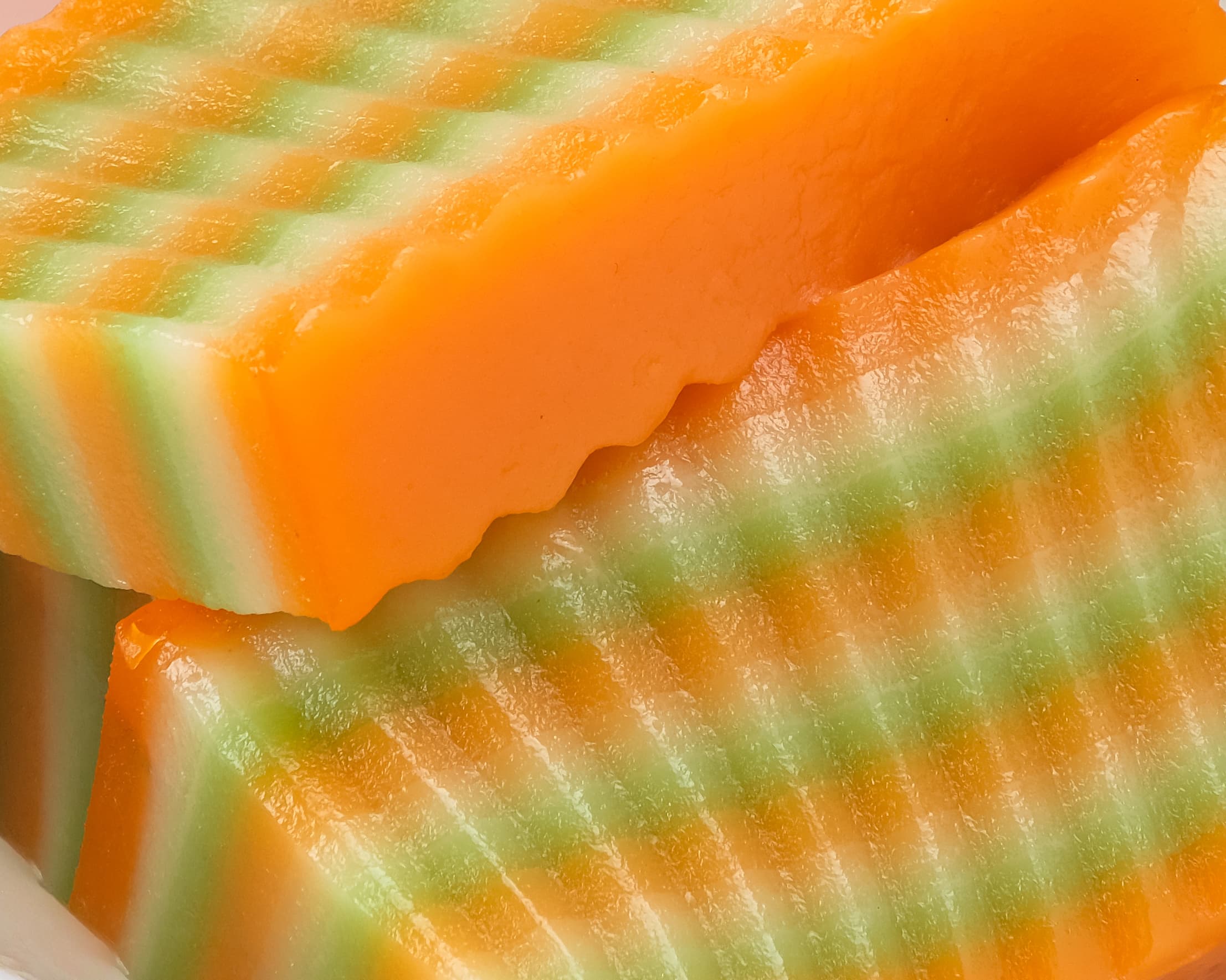 Close-up of layered orange, green and white kue lapis