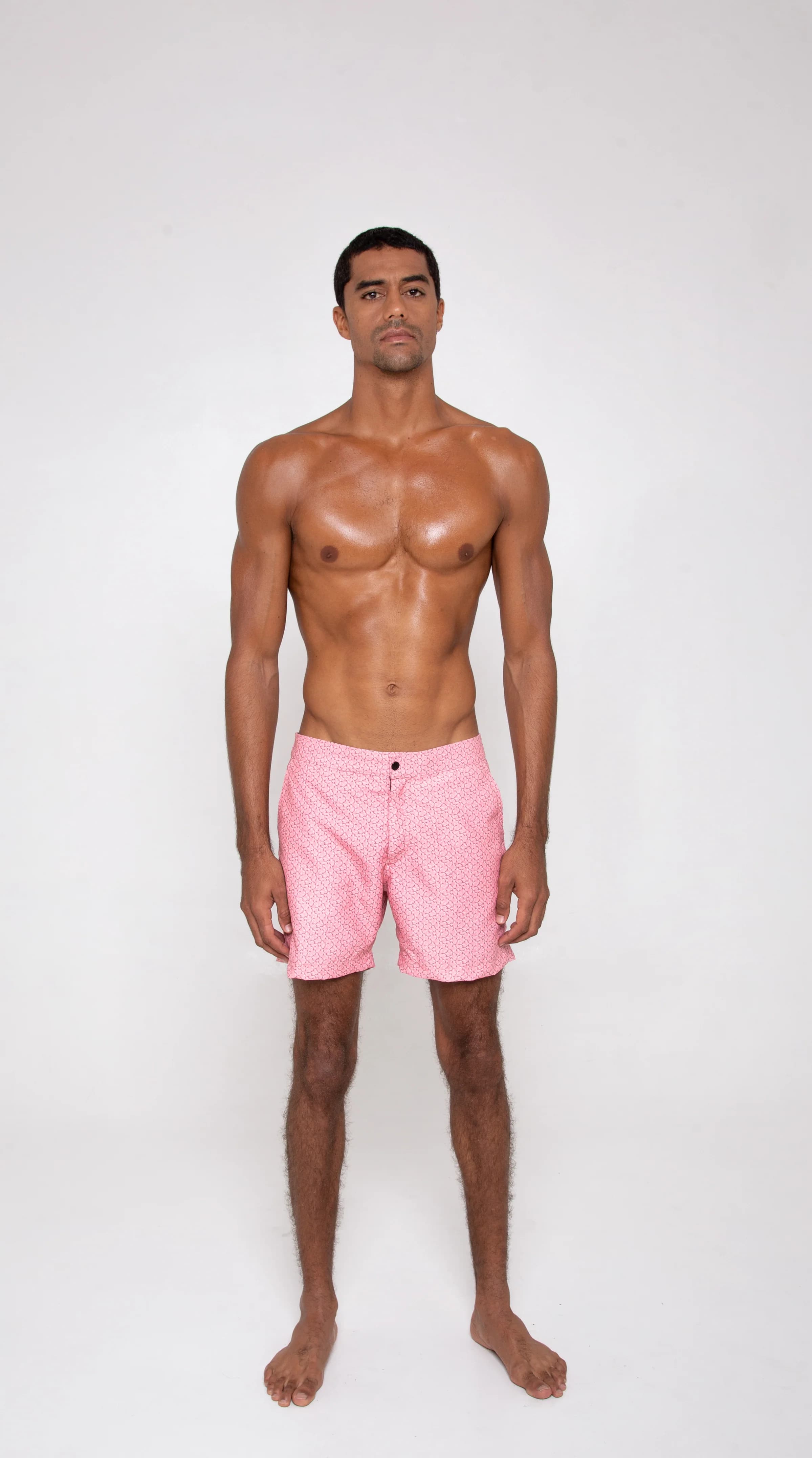 A man in pink swim shorts, seen from the front
