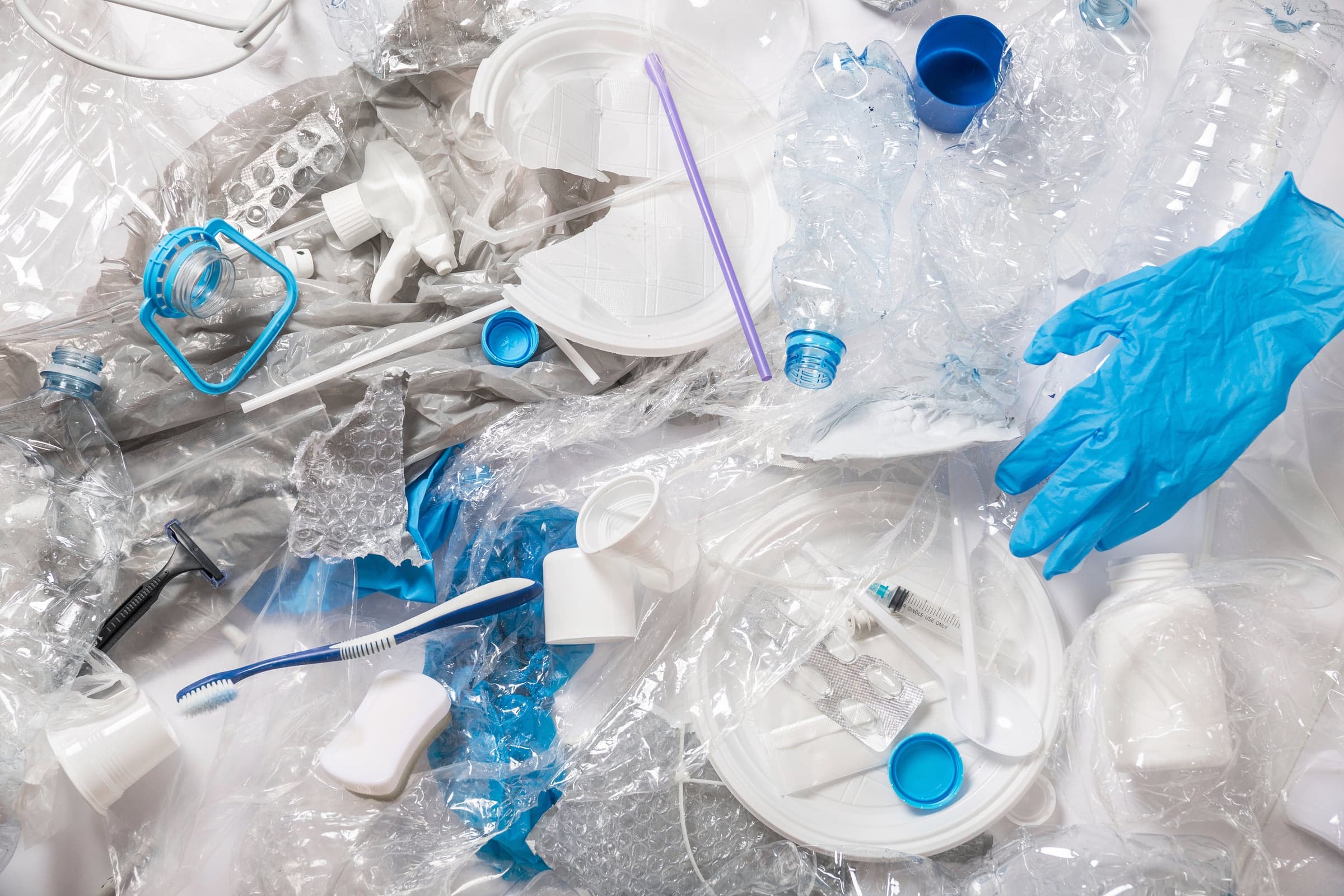 Single-use plastics sorted for recycling: bottles, caps, cutlery, a toothbrush and a glove