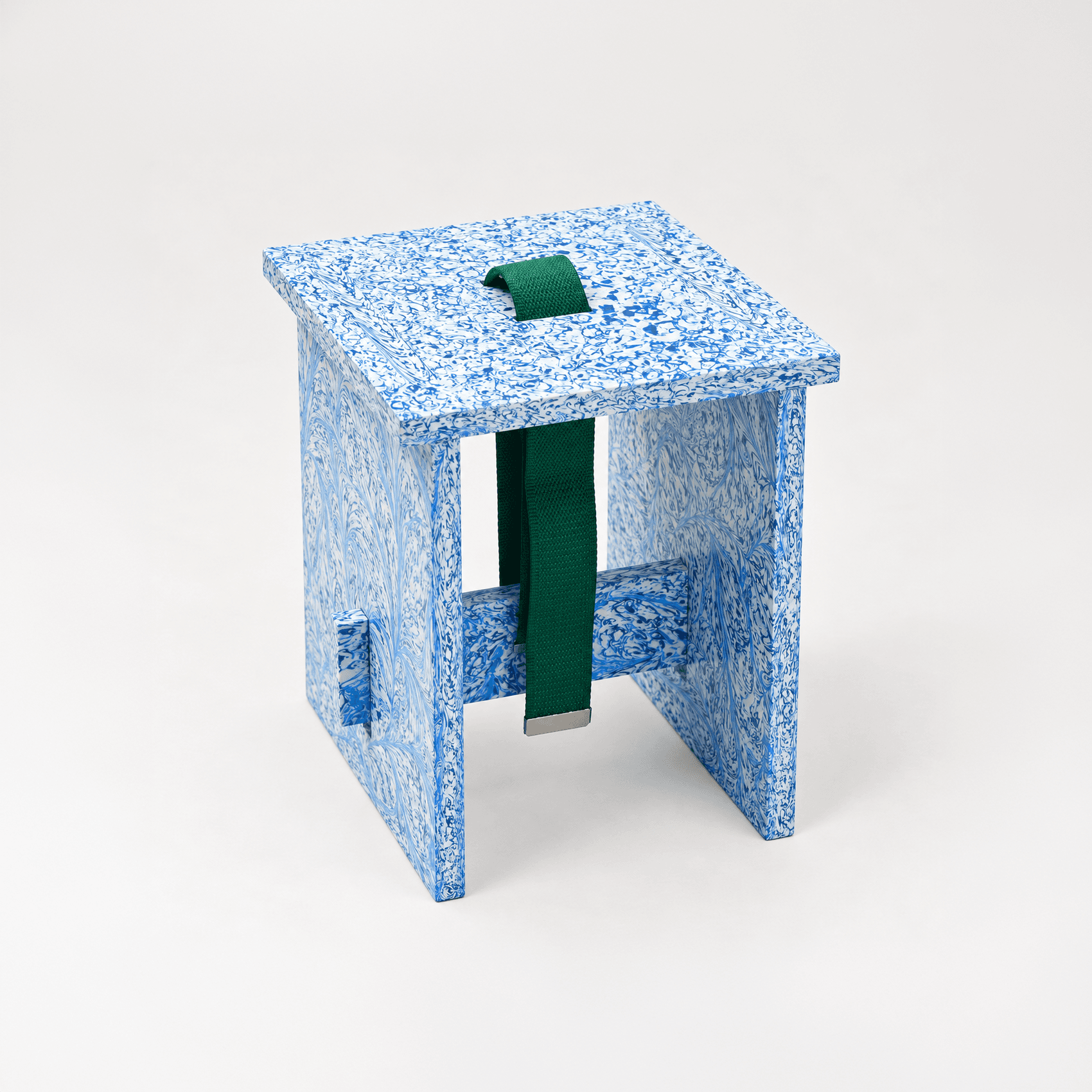 A flatpack chair of speckled blue recycled plastic with a green strap