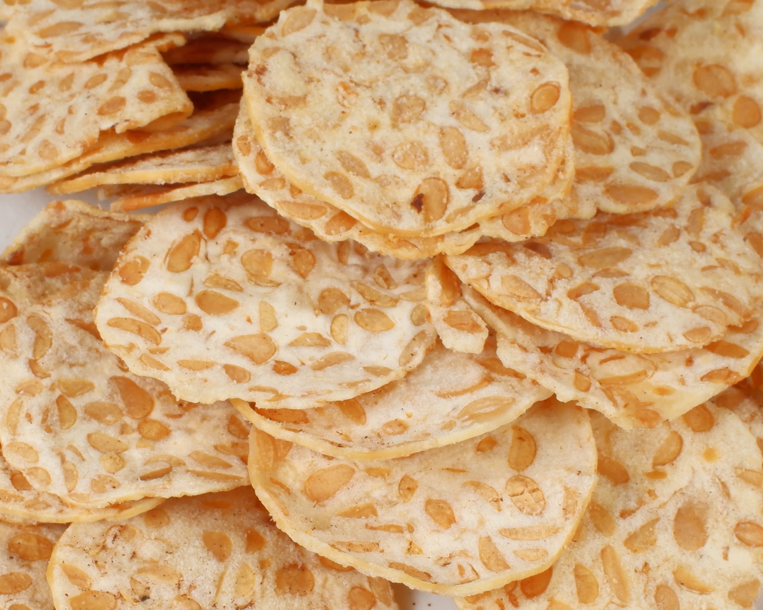 A pile of thin, golden tempe chips